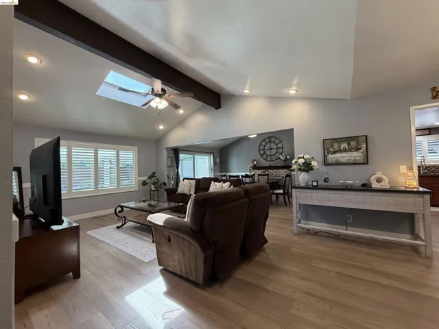 Vaulted ceiling with exposed beam, recessed lighting, and a skylight