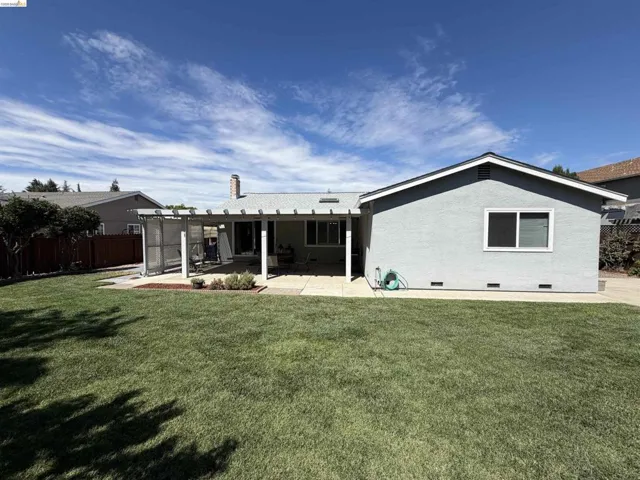 Expansive backyard featuring a large lawn area and a paved patio