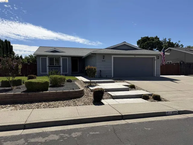 Single-story residence featuring a gray exterior and an attached garage