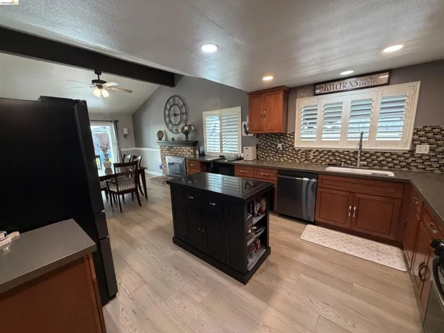 Kitchen featuring wood-finish flooring, dark wood cabinetry, and stainless steel appliances