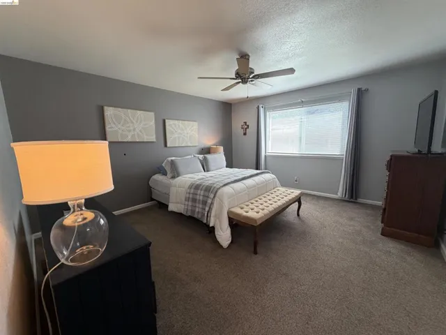 Spacious room featuring neutral carpeting and a ceiling fan