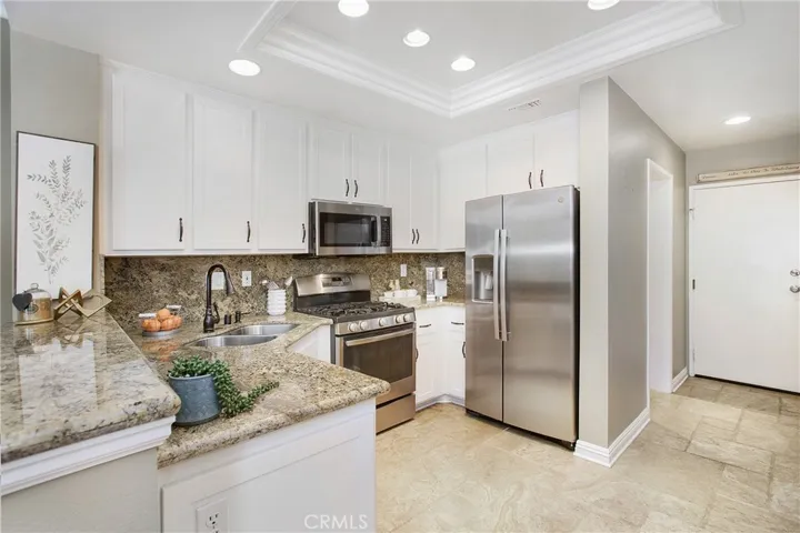 White shaker cabinetry with pull out drawers and recessed lighting
