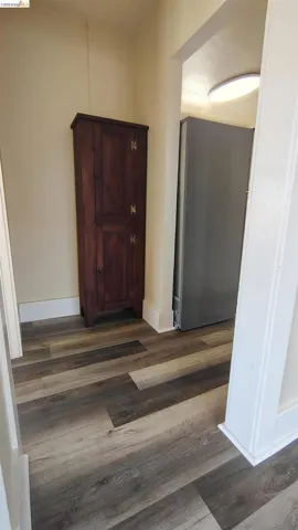 Wood-finish flooring throughout, featuring a recessed ceiling light and white baseboards