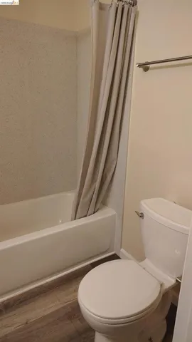 Full-sized bathtub and shower combination with speckled surround