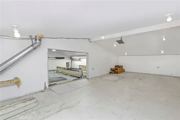 Storage Over Flex Space looking out to garage w/ drop down stairs (Attic)