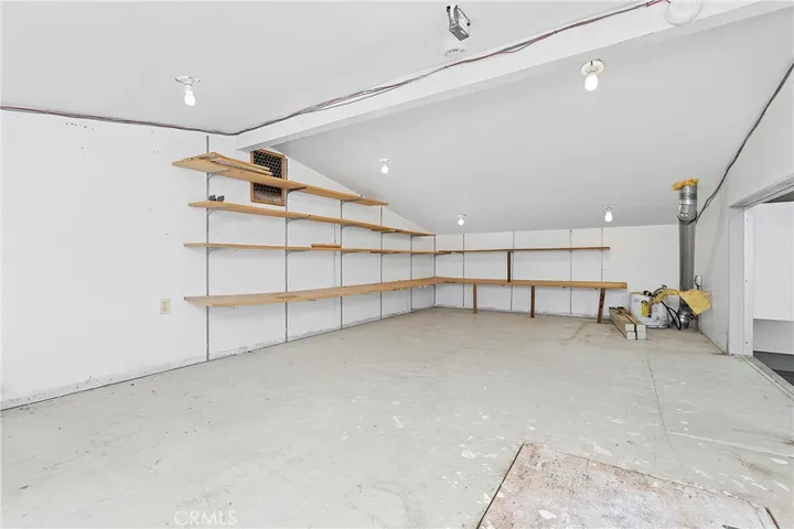 Storage Over Flex Space looking out to garage w/ drop down stairs (Attic)