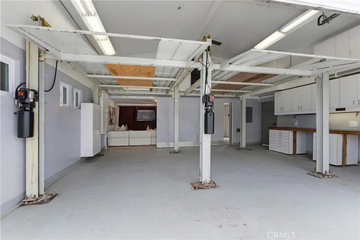 Original Photo -2 Car Lifts to make a 4 Car Garage -Sliding Wall OPEN to Flex Space/Bonus Room - Potential to be 5 Car Garage
