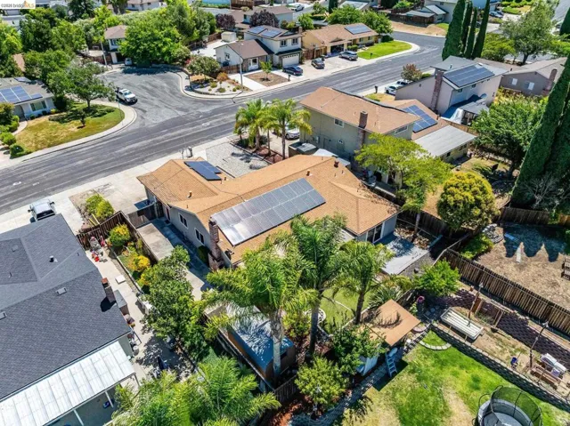 Single-story residence featuring a brown shingle roof with multiple solar panel arrays