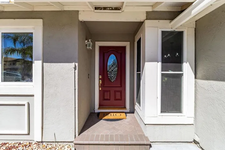 Striking red entry door with decorative glass paneling