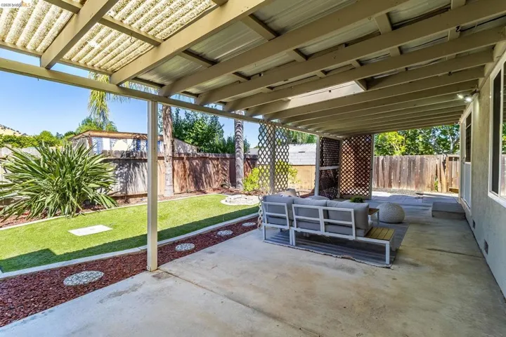 Outdoor patio featuring a solid roof cover, concrete flooring, and decorative lattice panels