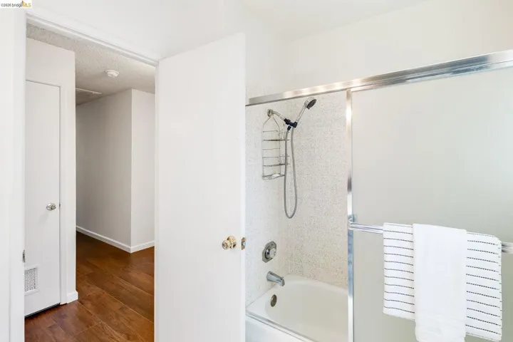 Full bath featuring a tub and shower combination with frosted sliding glass doors