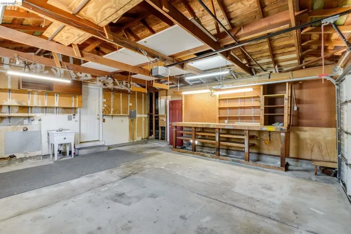 Spacious garage with exposed beam ceiling and concrete flooring