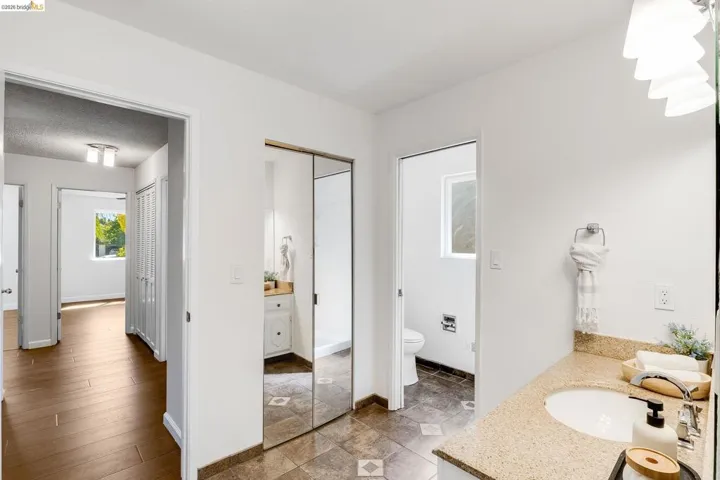 Bathroom vanity featuring a light speckled countertop, undermount sink, and chrome faucet