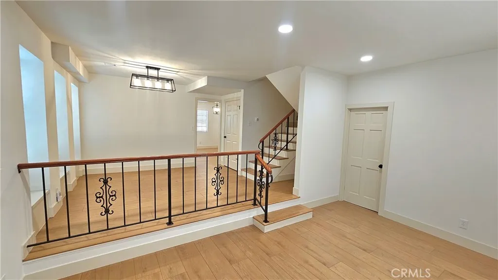 Dining room/den, door to garage stairs on far right, stairs to bedrooms just left of garage door