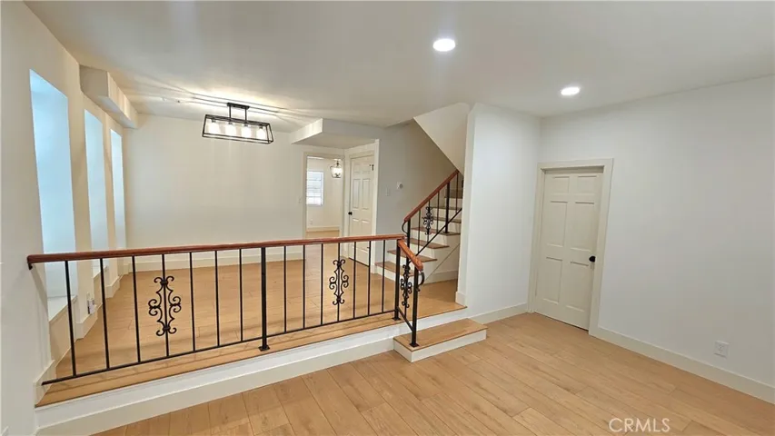 Dining room/den, door to garage stairs on far right, stairs to bedrooms just left of garage door