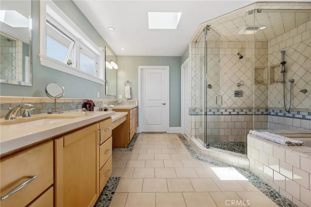 Spa-inspired bath with separate tub and step-in shower, dual sinks, center vanity, private water closet, skylight. Spa-inspired bath with separate tub and step-in shower, dual sinks, center vanity, private water closet, skylight.