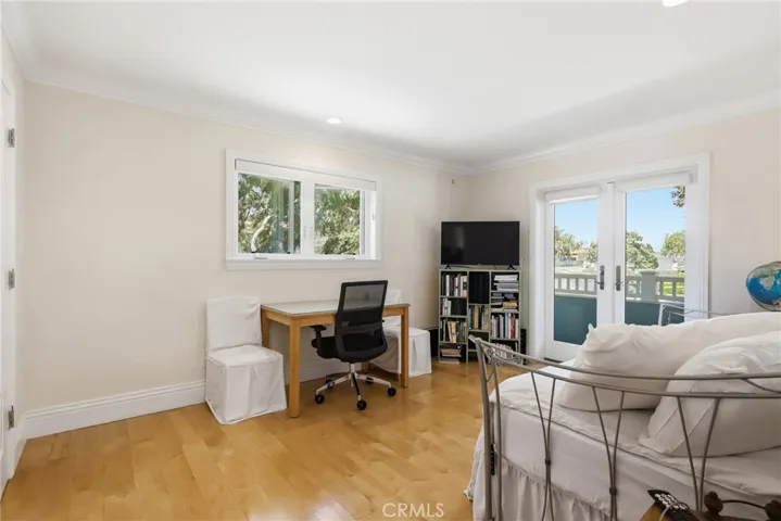 Guest bedroom on second level with doors to balcony.