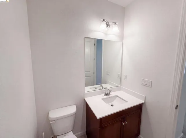 Bathroom vanity featuring a polished chrome faucet, under-mount sink, and white countertop