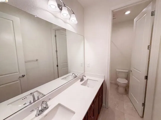 Bathroom featuring a double vanity with white countertops, undermount sinks, and chrome fixtures