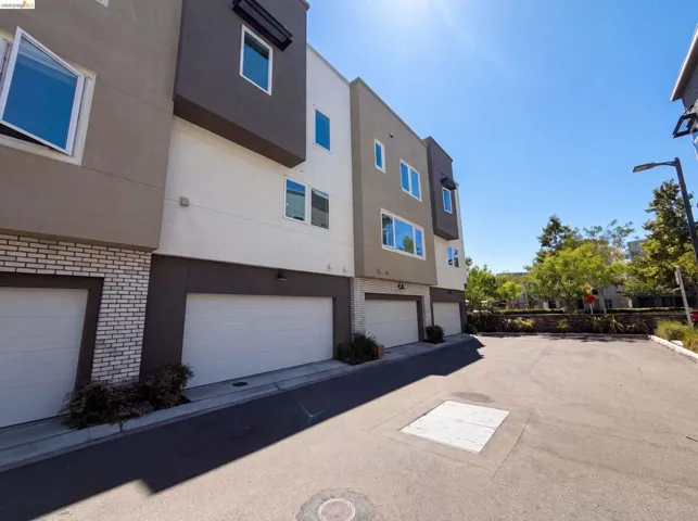 Contemporary multi-story exterior with a mixed material façade featuring light brick, stucco, and dark accents