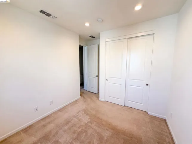Neutral-toned carpeting paired with white walls, baseboards, and trim