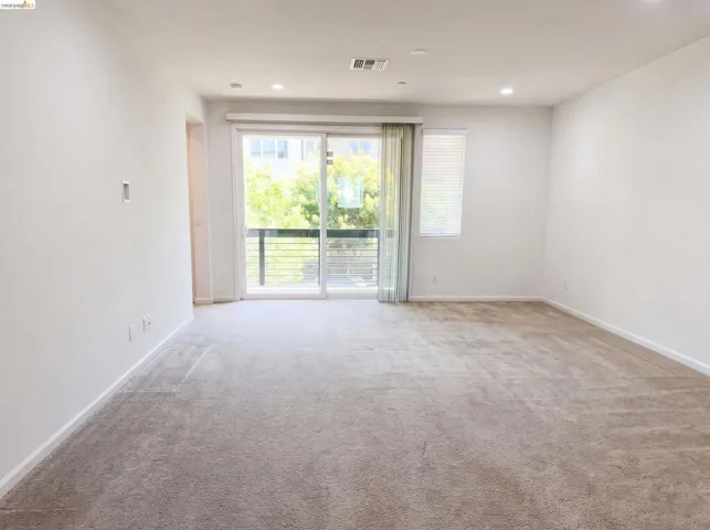 Spacious room with light-toned carpeting and recessed lighting