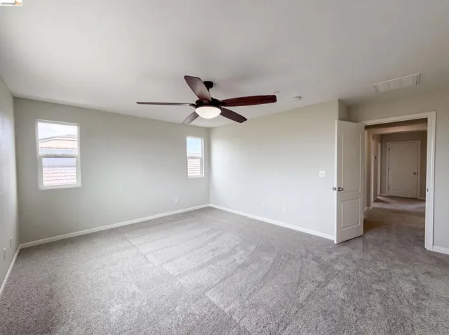 Spacious room featuring neutral carpeting and light-colored walls