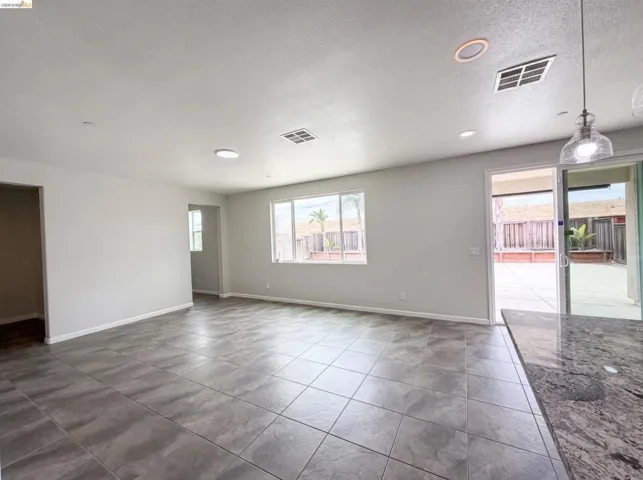 Expansive living area featuring large format tile flooring, recessed lighting, and a neutral color palette