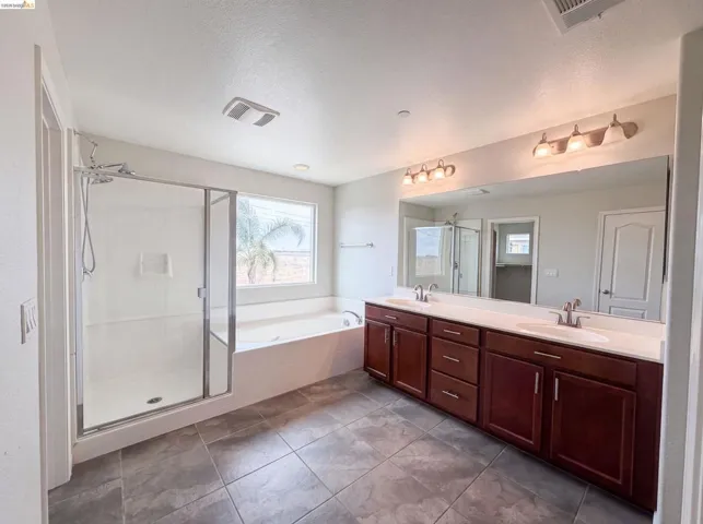 Dual vanity with dark wood cabinetry, white countertops, and brushed nickel fixtures