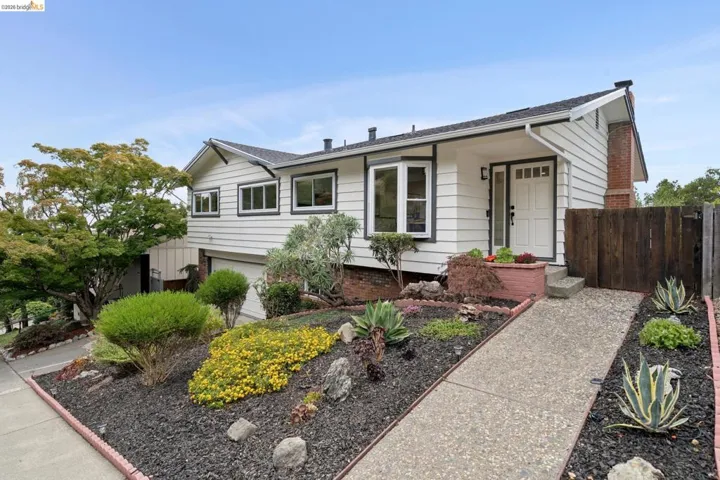 White horizontal siding exterior with dark trim accents and a bay window
