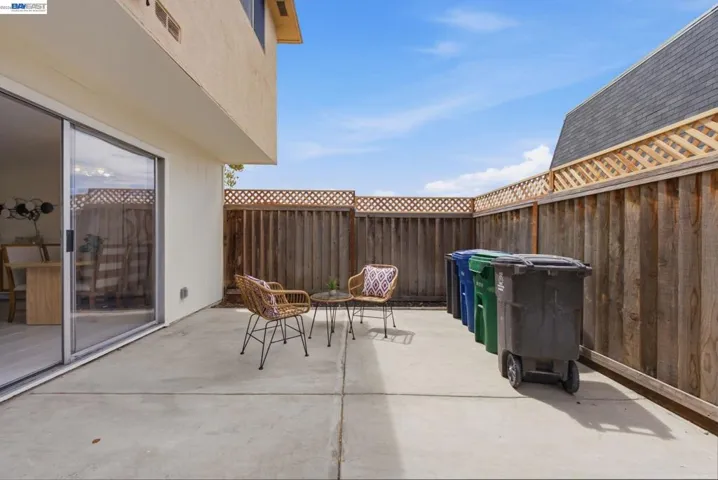 Private concrete patio featuring perimeter wood fencing with lattice accents