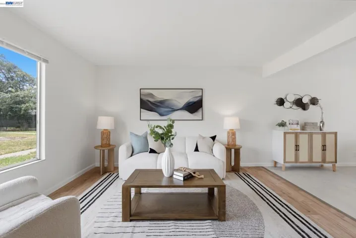 Bright living space featuring expansive windows, light wood-finish flooring, and white walls