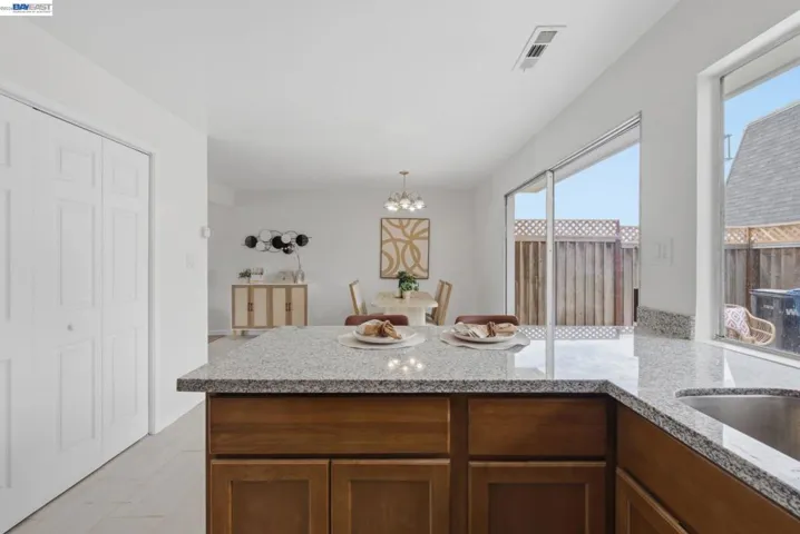 Kitchen with granite countertops, wood-finish cabinetry, and stainless steel sink