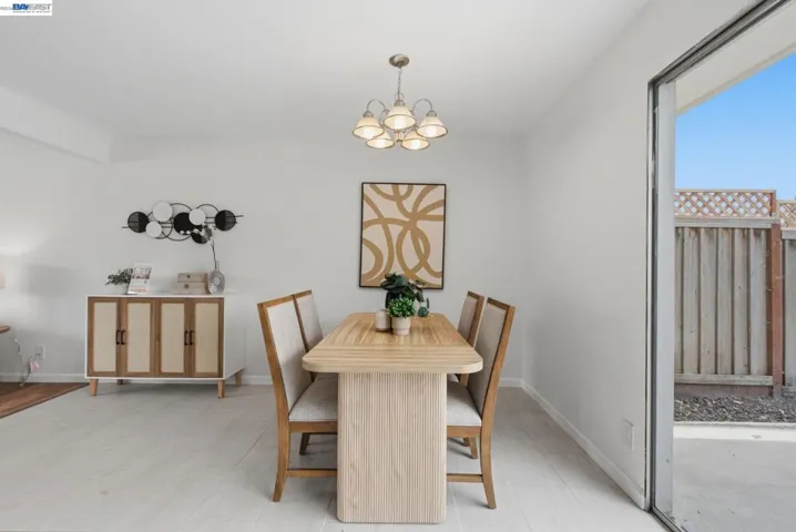 Dining area featuring light-tone flooring, a ceiling-mounted light fixture, and direct access to an outdoor patio space