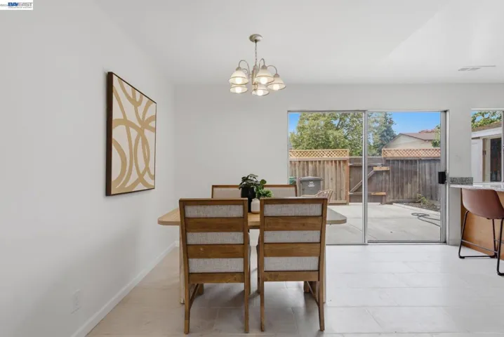 Dining area with light-toned tile flooring and a multi-light chandelier