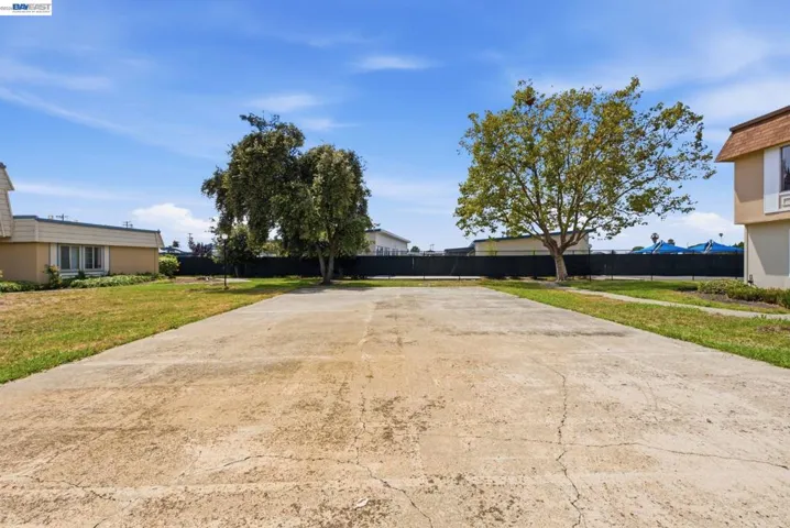 Expansive concrete slab surrounded by grass and mature trees