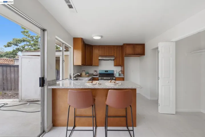 Open-concept kitchen with wood cabinetry and light-toned countertops