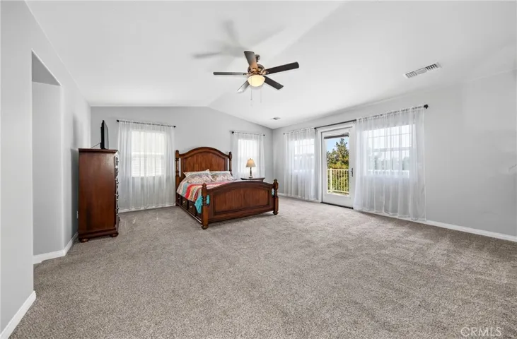 Spacious primary bedroom featuring neutral paint, plush carpeting, and large windows that provide an abundance of natural light