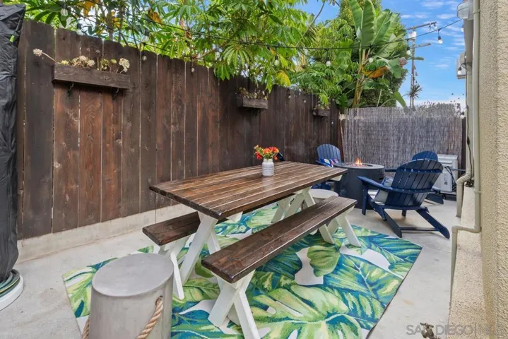 Spacious, private patio with picnic table, hanging "cafe" lighting, outdoor rug