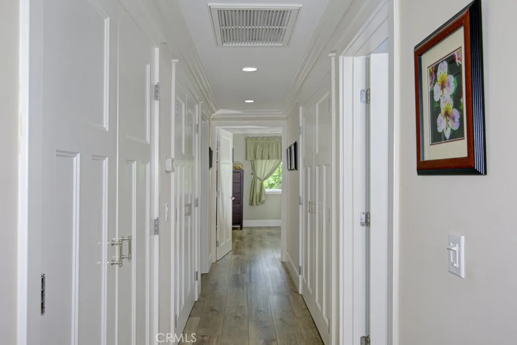 Hallway leading to bedrooms and bathrooms. There is a large closet on the lefthand side extending the length of the hallway that currently serves as a pantry.