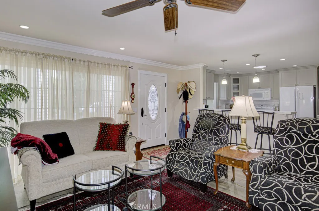 Another view of the living room. Windows at left look onto the front patio. Kitchen can be seen at right.