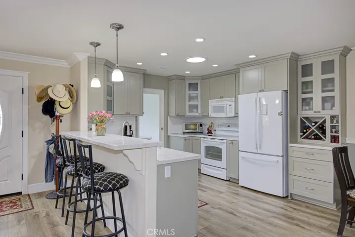 Kitchen and breakfast bar which can seat up to four. Front door can be partially seen at far left.