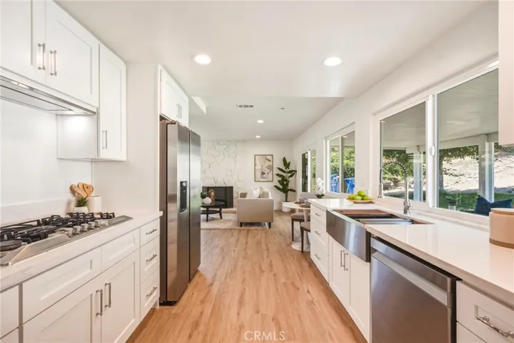 Chef’s kitchen with quartz countertops and backsplash, soft-close cabinetry, and an industrial-style faucet with upgraded accessories
