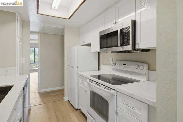 Well-appointed kitchen featuring white cabinetry and light-toned countertops