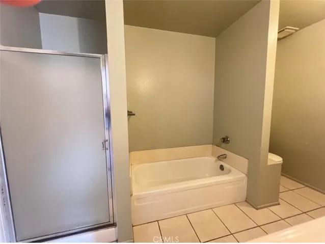The bathroom equipped with both a soaking bathtub and a separate walk-in shower.