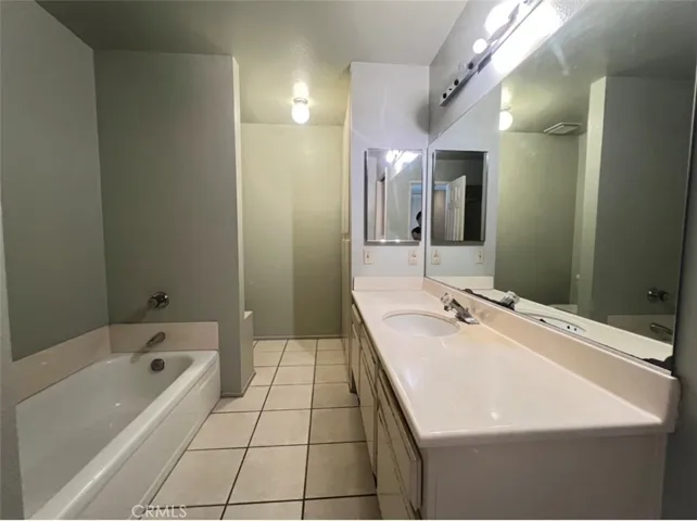The bathroom equipped with both a soaking bathtub and a separate walk-in shower.