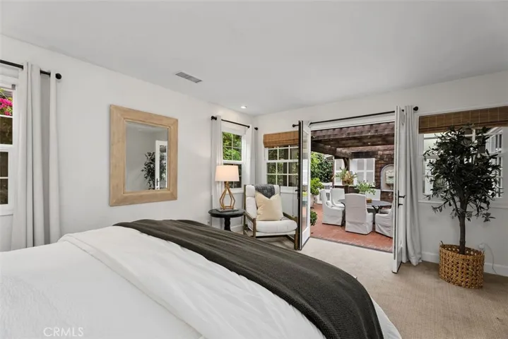 Primary bedroom opens with French doors leading out to the courtyard.