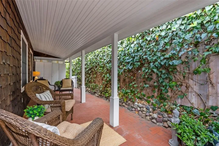 Side brick patio with overhang, perfect for afternoon reading a book or enjoying a beverage.