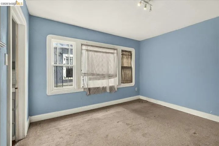 Room featuring light blue walls, white trim, and track lighting