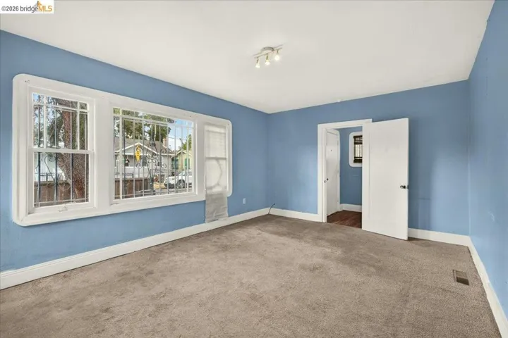 Room featuring neutral carpeting, light blue walls, and white trim